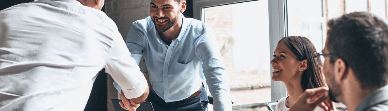 Young professionals in a business meeting. Two men are shaking hands.