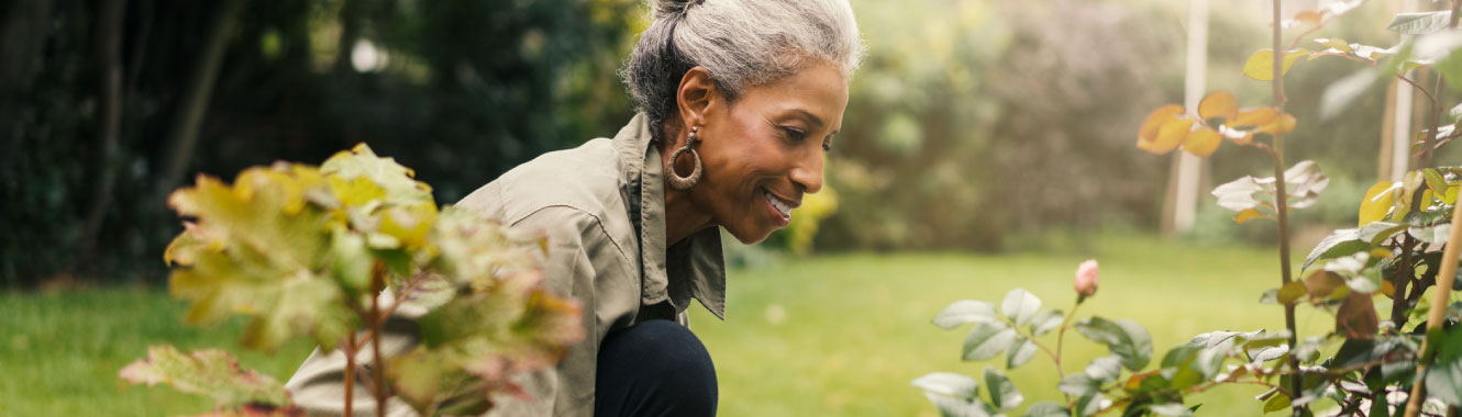 A senior woman tending to a garden. 